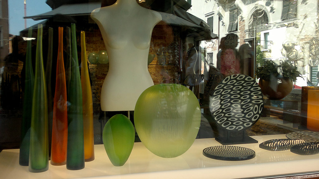 Einblick in ein Schaufenster in Venedig, in dem Glaswaren ausgestellt sind.