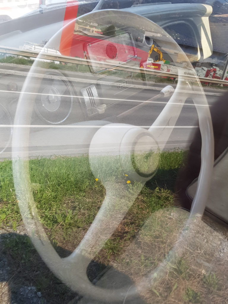 Fotografie auf ein Lenkrad eines DKWs, aufgenommen durch die Autoscheibe